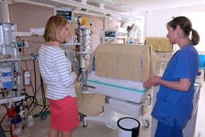 Freudenstein (Krankenhaus Barmherzige Brüder Regensburg
) Zu sehen ist Frau Freudenstein, blond, mit einer Angestellten. Sie stehen neben einer Art Baby-bett.