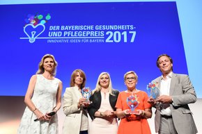 Preisverleihung (Foto: StMGP) Ministerin Huml (Mitte) verleiht den Bayerischen Gesundheits- und Pflegepreis und zeichnet drei innovative Projekte aus Ansbach, Regensburg sowie den Landkreisen Traunstein und Berchtesgadener Land aus. Krankenhaus-Geschäftsführerin Sabine Beiser (2.v.r.) von der Regensburger Klinik St. Hedwig nahm den Preis für das neue Flüchtlingskonzept der Klinik entgegen.