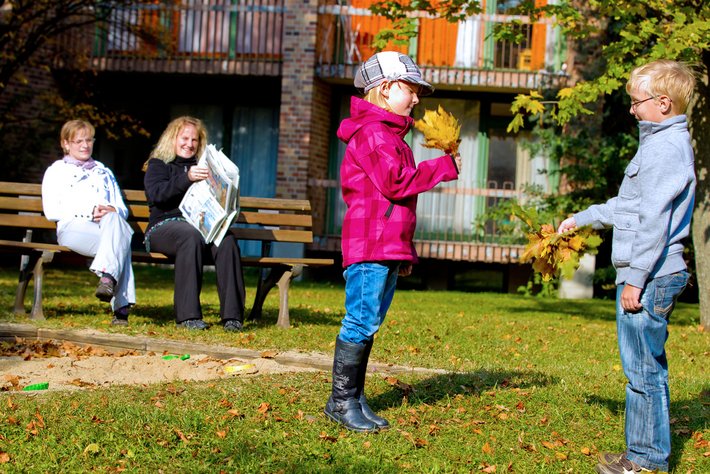 Kinder spielen im herbstlichen Park der Klinik St. Hedwig