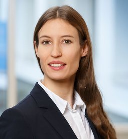 Linda Plail (Foto: Clemens Mayer) Frau Plail hat langes braunes welliges Haar und lächelt freundlich. Sie trägt ein weißes Hemd und einen Blazer