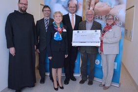 KUNO-Klinik St. Hedwig: Neue sozialmedizinische Familiennachsorge für Ostbayern (Krankenhaus Barmherzige Brüder Regensburg) Auf dem Bild sind 6 Personen zu sehen. Der zweite von rechts außen hält den Scheck in seinen Händen.