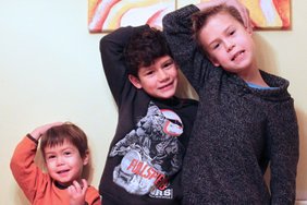 Auf dem Bild sind drei Jungen zu sehen, der Größe nach geordent. Jeder fasst sich mit dem rechten Arm an das linke Ohr. Wenn das problemlos klappt, können sie unbesorgt Nüsse essen.