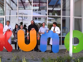 Mitglieder der Klinikleitung vor dem KUNO-Logo