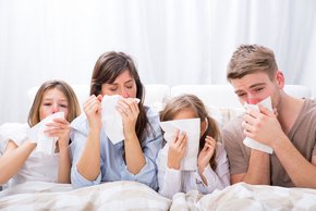 RS-Virus (Fotolia) Auf dem Foto ist eine Familie zu sehen, die verschnupft ist. Die zwei Erwachsenen, so wie die zwei Kinder halten ein Taschentuch in der Hand und schneuzen.