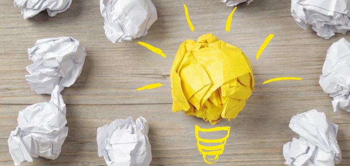 Eine Birne und Papierbälle stehen für "Idee, Konzept"