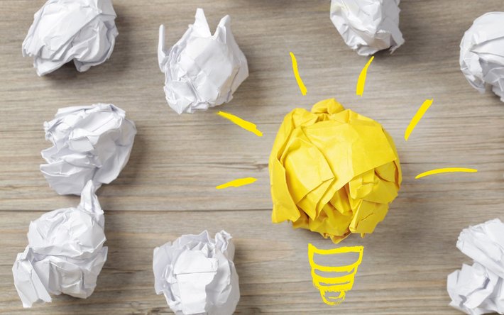 Eine Birne und Papierbälle stehen für "Idee, Konzept"