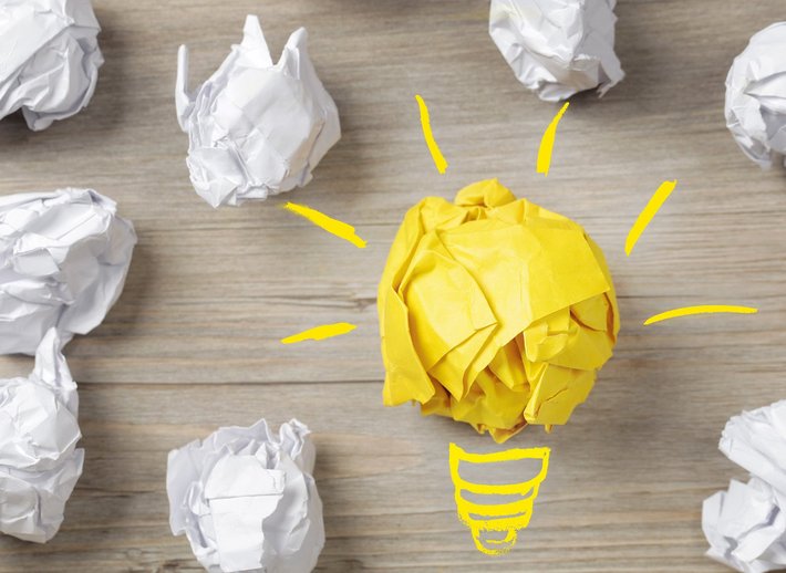 Idee, Konzept (Foto: Bounlow | fotolia.com) Eine Birne und Papierbälle stehen für "Idee, Konzept"