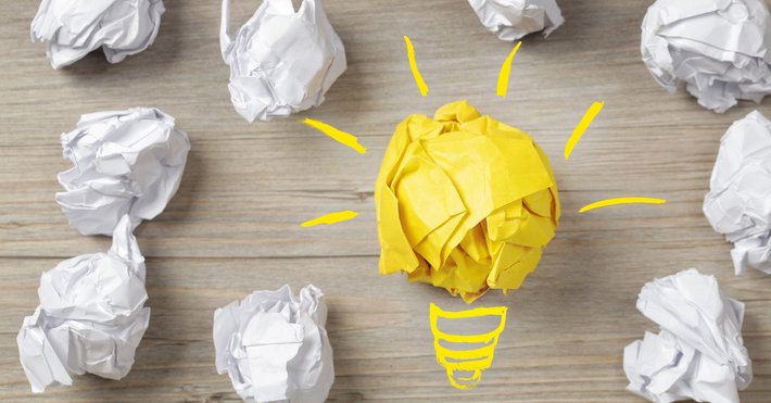 Eine Birne und Papierbälle stehen für "Idee, Konzept"