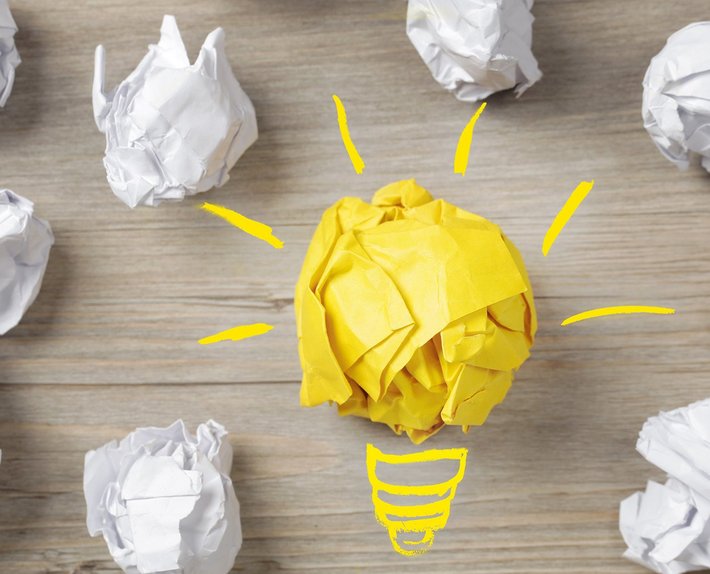Idee, Konzept (Foto: Bounlow | fotolia.com) Eine Birne und Papierbälle stehen für "Idee, Konzept"