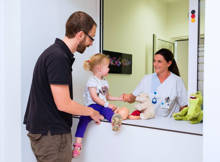 Patientenaufnahme St. Hedwig (Foto: Paul Mazurek) Ein Vater meldet seine Tochter für den ambulanten Eingriff an der Patientenaufnahme an.